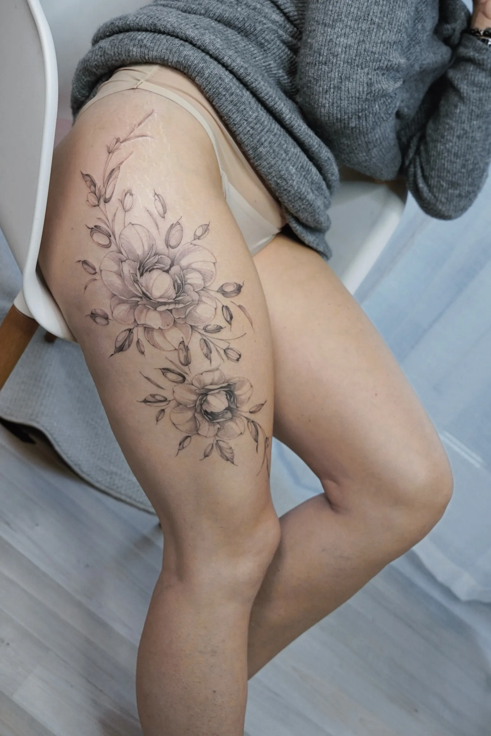 Fine Line Blumen Tattoo Oberschenkel