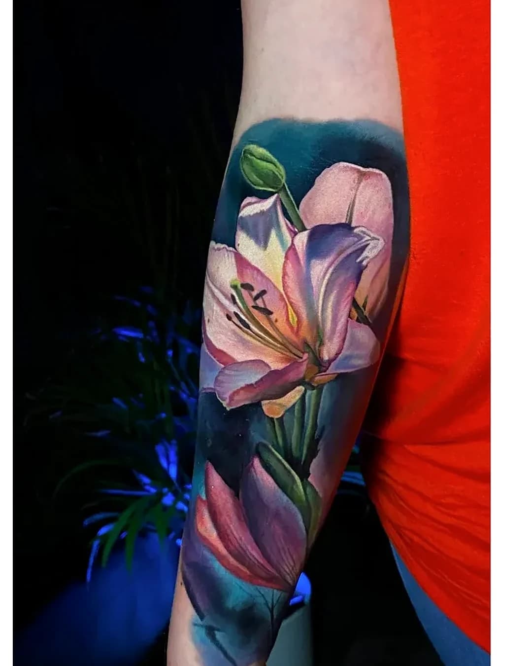 Cover-up Tattoo Villingen-Schwenningen: altes Schmetterling-Tattoo überarbeitet zu einer farbigen Lilie am Unterarm